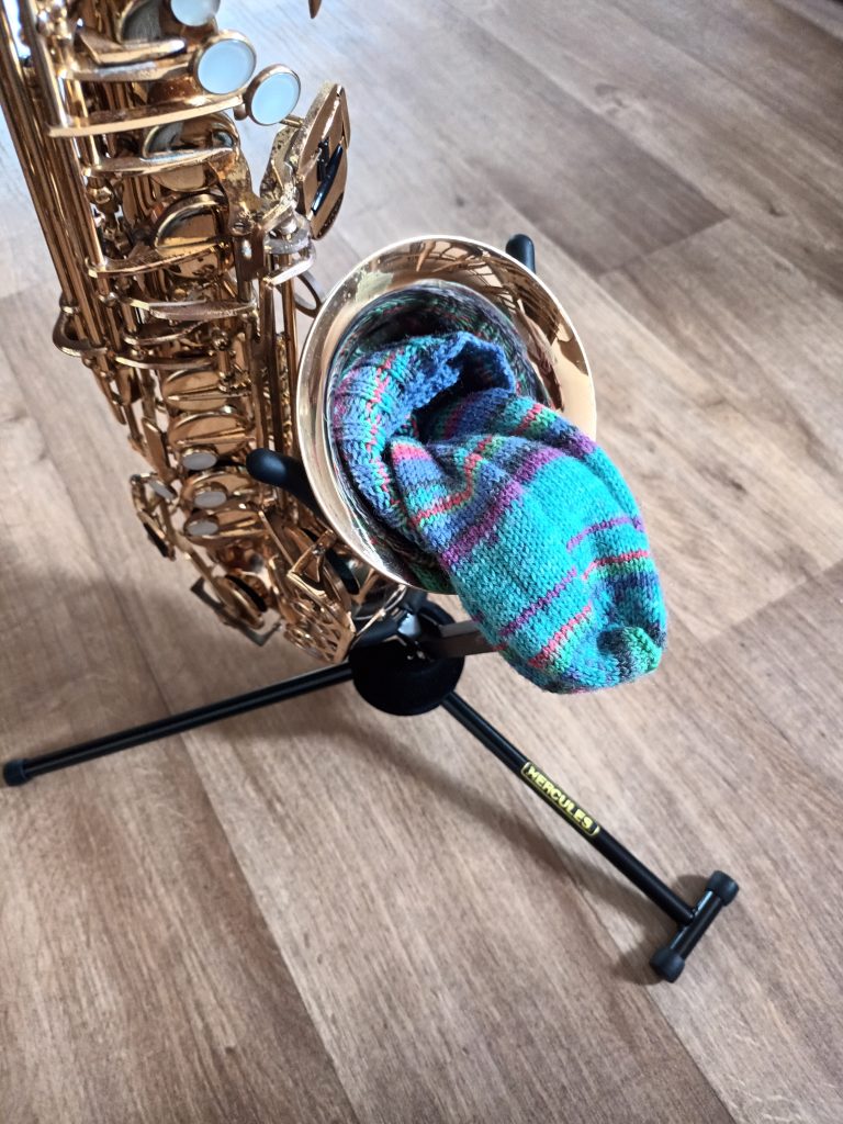 Put socks in saxophone bell A rolled ball of socks in the bell of saxophone