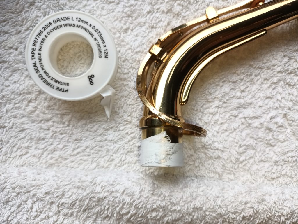 Saxophone neck with teflon tape to fix leaks Temporarily fix a leaking saxophone neck with teflon tape.