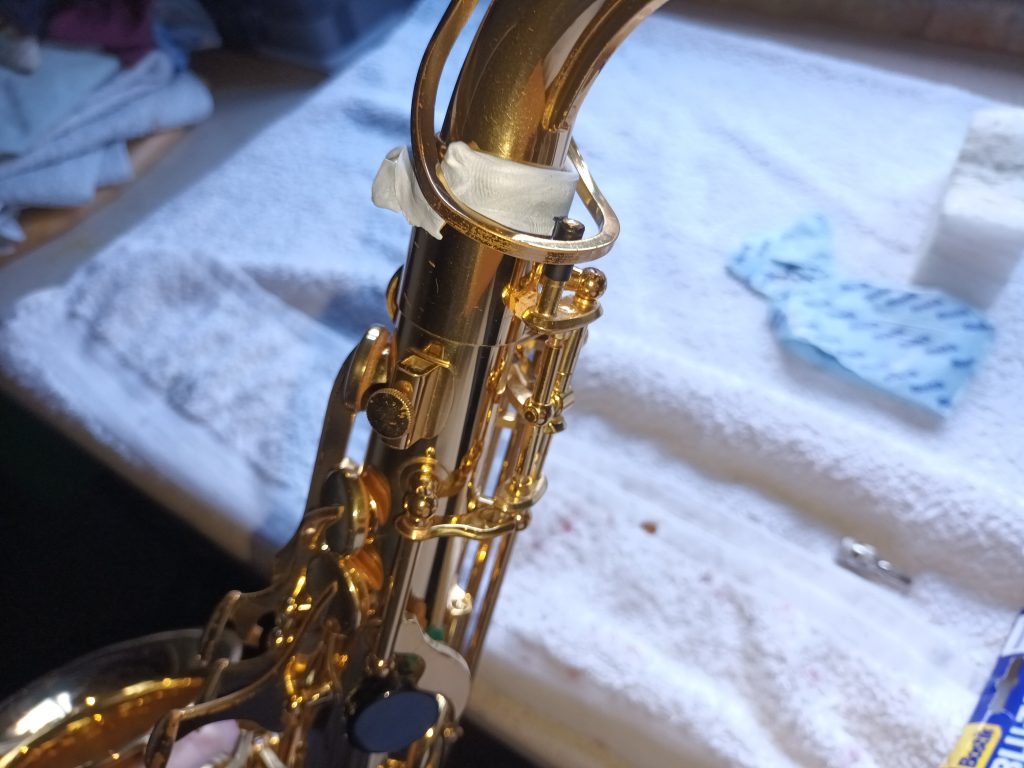 Use putty as a temporary repair Saxophone neck socket wrapped in putty